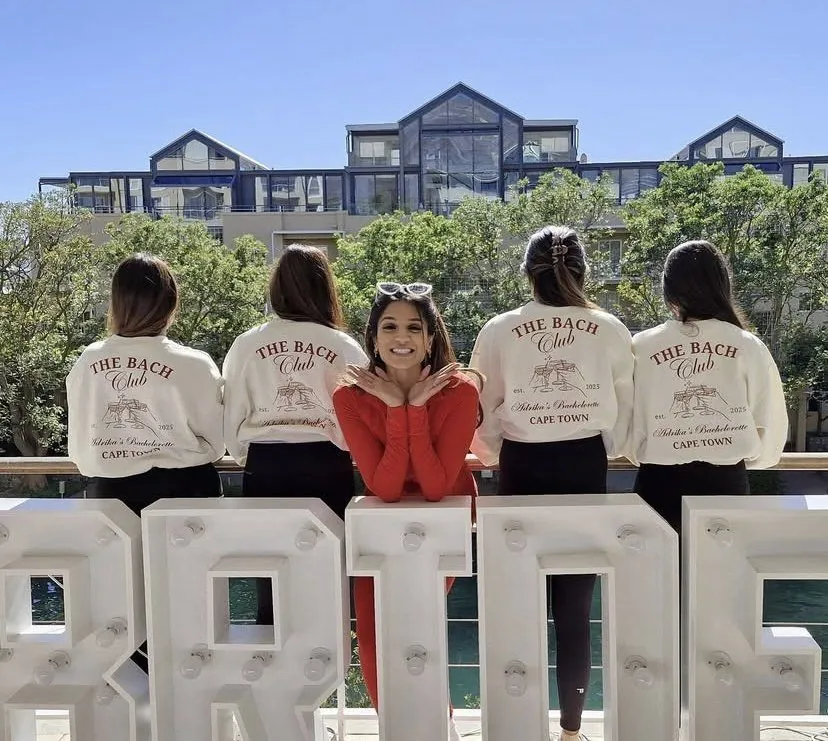 Bridal party in The Bach Club Cape Town sweatshirts at a BRIDE marquee by the V&A Waterfront, Cape Town