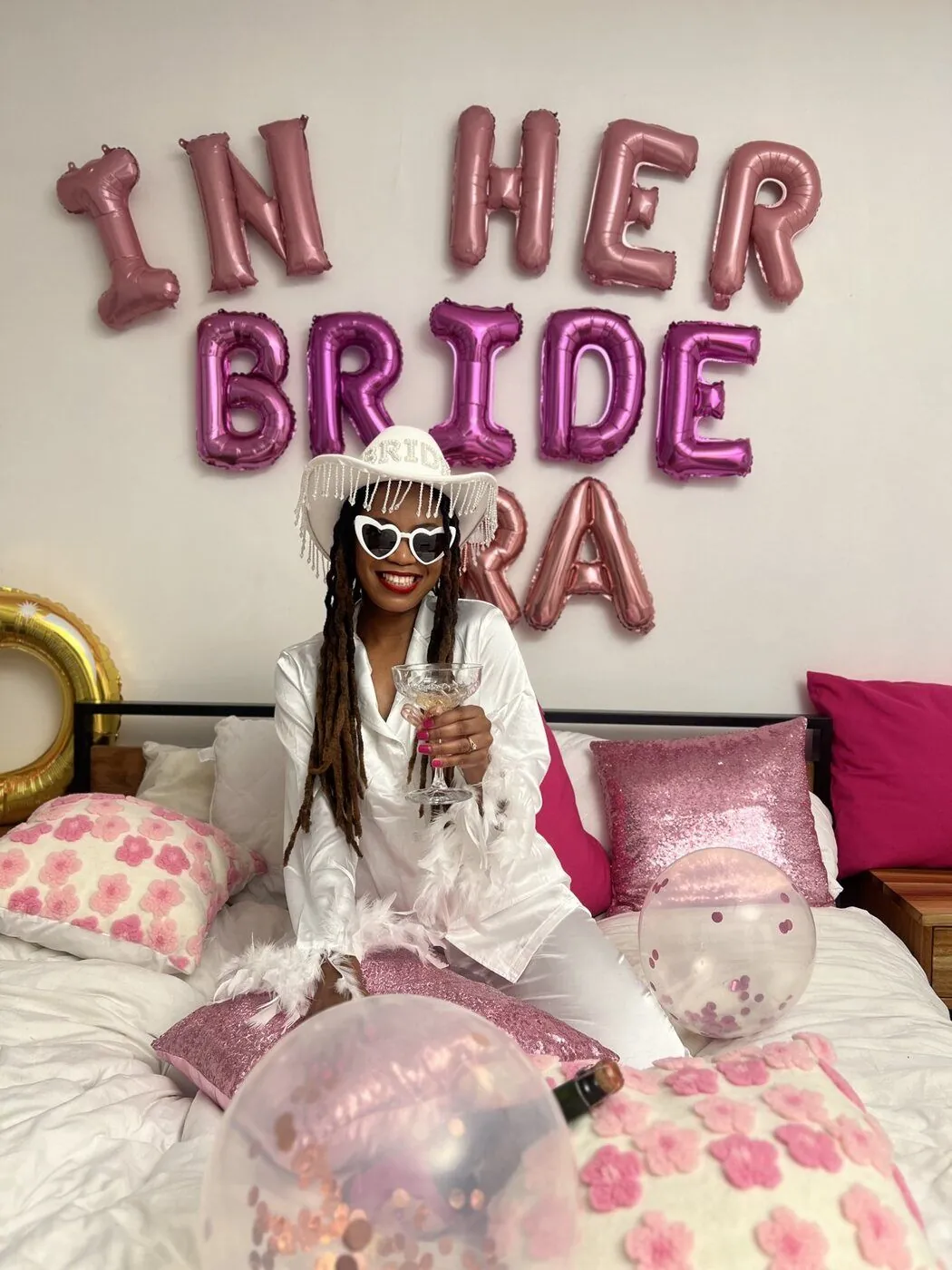 Bride celebrating with a branded bach bottle under BRIDE ERA balloons