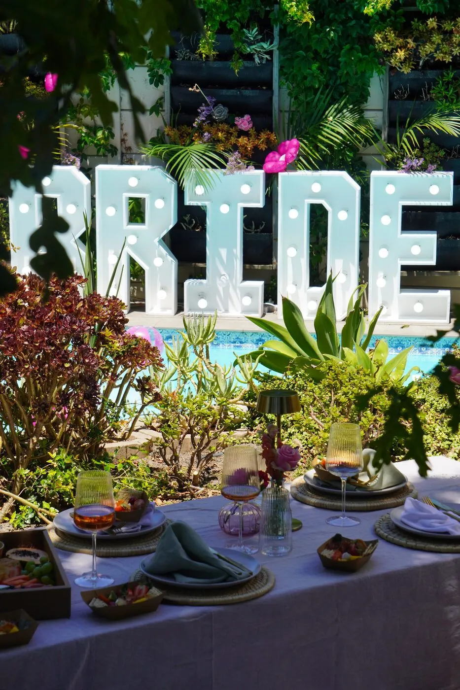 Styled outdoor picnic table by the pool with a BRIDE marquee, Cape Town