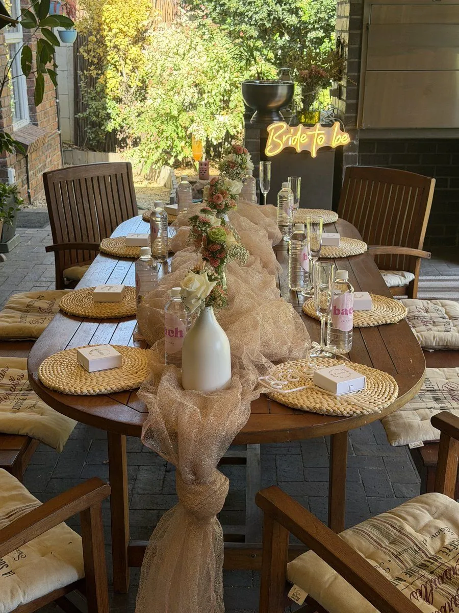 Styled outdoor bachelorette tablescape with a Bride to be neon and branded bach details